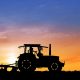 Tractor in field carrying out agric mechanization while the sun sets